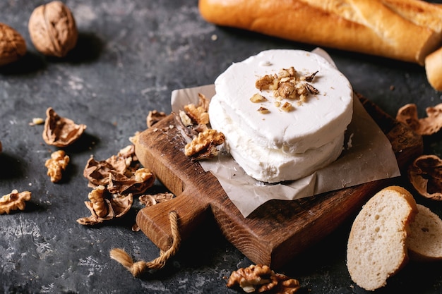 Formaggio di capra servito con miele e noci su sfondo scuro trama. Copia spazio