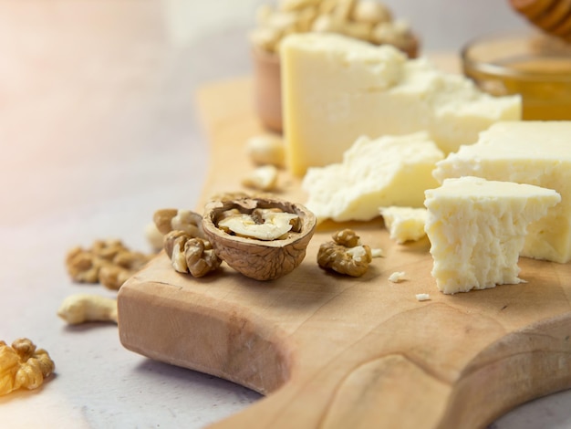 Formaggio di fattoria servito con miele e noci su uno sfondo di texture leggera. Copia spazio