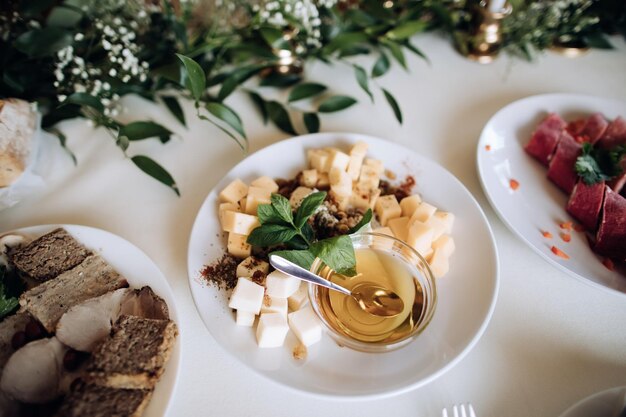 Formaggio e miele assortiti su un piatto su un tavolo per le vacanze a una festa