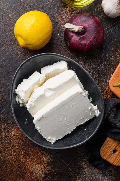 Formaggio feta tradizionale in ciotola nera, vista dall'alto.