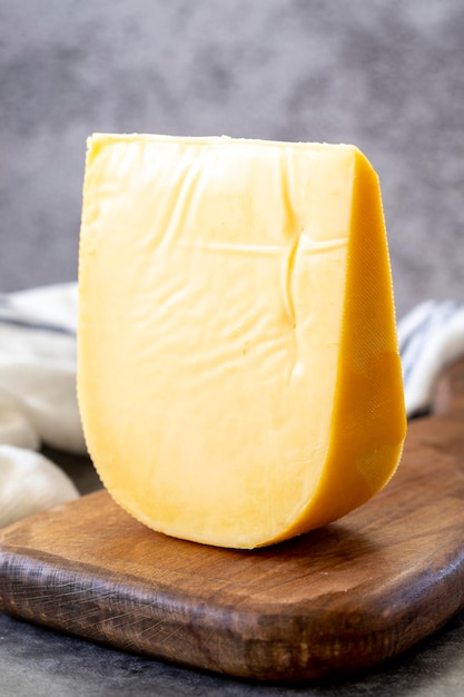 Formaggio gouda giallo formaggio gouda olandese duro su sfondo scuro da vicino