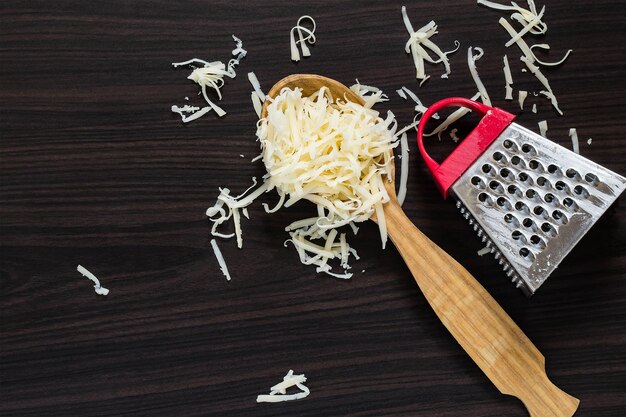 Formaggio grattugiato nel cucchiaio e grattugia