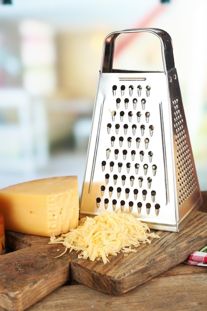 Formaggio grattugiato sul tagliere di legno su sfondo sfocato