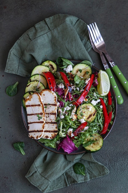 Formaggio halloumi alla griglia con verdure grigliate e insalata verde. Concetto di cibo sano.