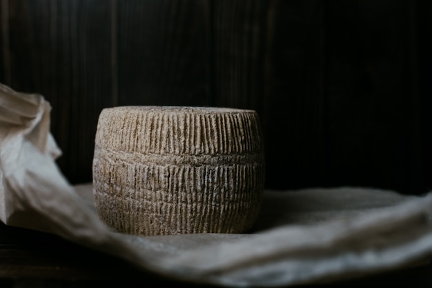 formaggio kravot e carta pergamena. Cerchio di formaggio duro fatto in casa in chiave di basso. Il concetto di formaggio di fattoria fatto in casa con latte di mucca