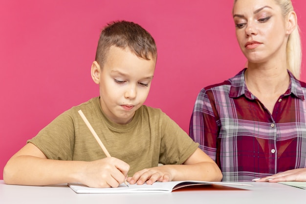 Formazione a distanza insieme. Mamma con figlio a fare i compiti insieme a casa.