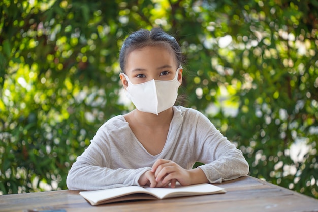 Formazione online a distanza. bambino con una maschera per guardare una lezione online.