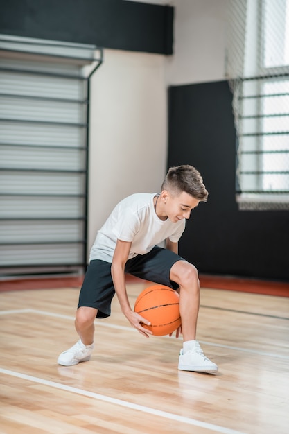 Formazione. Un ragazzo che gioca a basket in palestra e sembra coinvolto