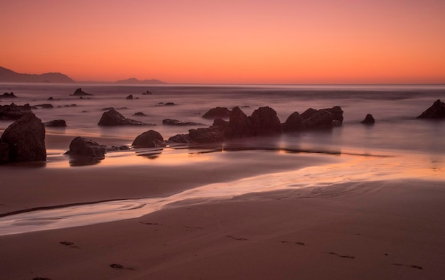 formazioni rocciose in spiaggia alla luce del tramonto