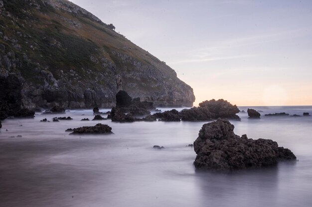 formazioni rocciose in spiaggia sotto la luce del tramonto