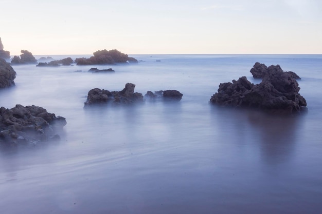 formazioni rocciose in spiaggia sotto la luce del tramonto