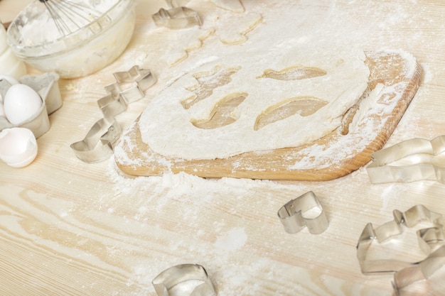 Forme metalliche per biscotti e pasta cruda su un tavolo