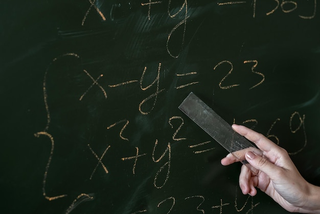 Formule matematiche di scrittura a mano femminile sulla lavagna, primo piano