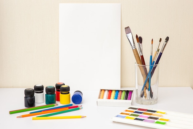 Forniture da disegno colorate su tavolo bianco mock up