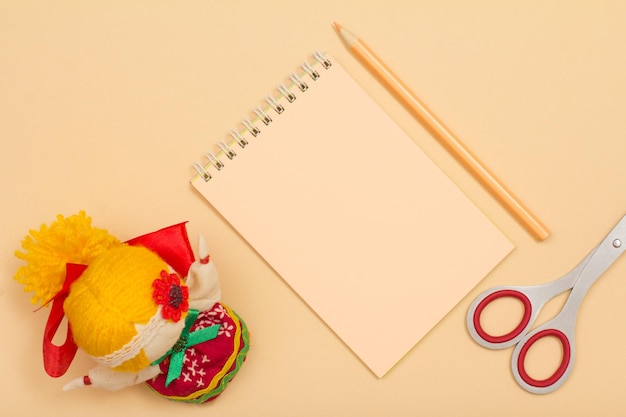 Forniture scolastiche Forbici per matite colorate per notebook e bambola su sfondo beige Vista dall'alto