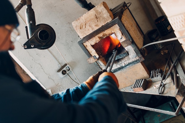 Forno da fabbro a fiamma calda. Smith mise dentro e riscaldò un pezzo di ferro d'acciaio nel fuoco di una fucina rovente