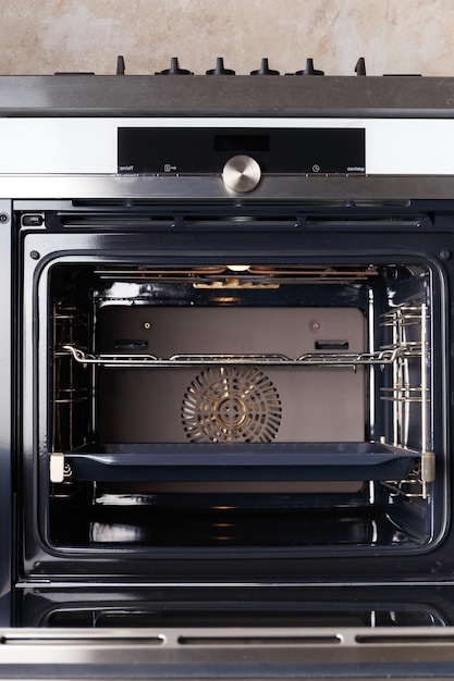 Forno elettrico da incasso con porta aperta all'interno della cucina Forno con display a convezione Elettrodomestici da incasso per la cucina