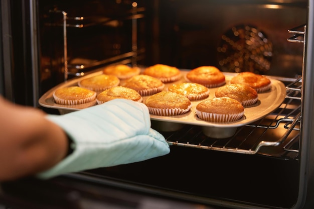 Forno manuale e muffin per cuocere il cibo o cucinare dolci deliziose torte su un vassoio a casa in cucina