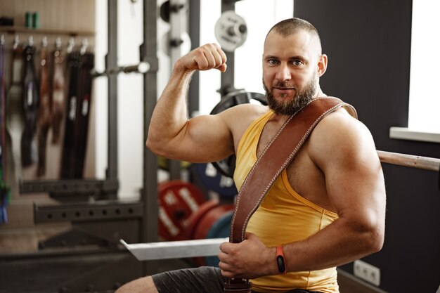 Forte bodybuilder con petto muscoloso e spalle in palestra