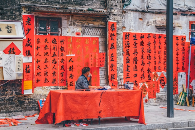 Foshan, provincia di Guangdong, Cina. 8 FEBBRAIO 2021. Persone che scrivono distici con i saluti per il Festival di Primavera. Preparazione per la celebrazione del capodanno cinese in via Kuaizi a Foshan