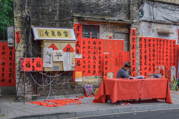 Foshan, provincia di Guangdong, Cina. 8 FEBBRAIO 2021. Un calligrafo sta scrivendo distici del Festival di Primavera per le persone. È l'usanza più comune e importante quando si celebra il capodanno cinese.