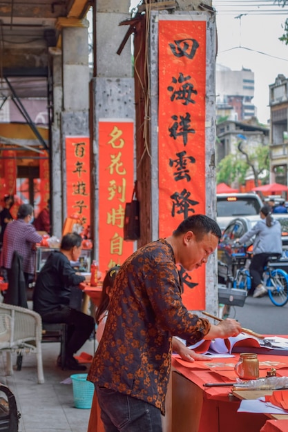 Foshan, provincia di Guangdong, Cina. 8 FEBBRAIO 2021. Un calligrafo sta scrivendo distici del Festival di Primavera per le persone. È l'usanza più comune e importante quando si celebra il capodanno cinese.