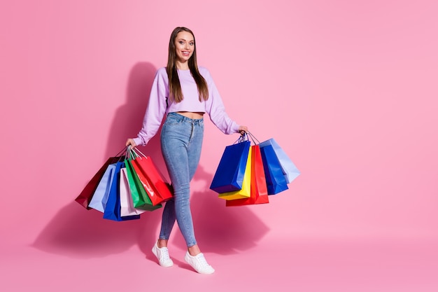 Foto a figura intera di una ragazza positiva e allegra dello shopping tenere molte borse godere del tempo libero shopping 50% vendita indossare lilla stile viola elegante maglione alla moda isolato sfondo color pastello