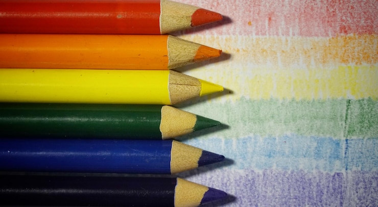 Foto foto a fotogramma completo di matite multicolori su un tavolo che simboleggia la bandiera lgbtq