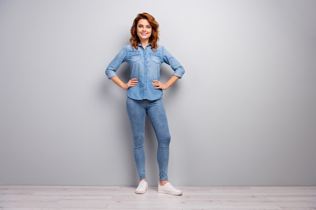 Foto a grandezza naturale di donna abbastanza adorabile mettere le mani in vita in posa guardare bene indossare abiti eleganti isolati su muro di colore grigio