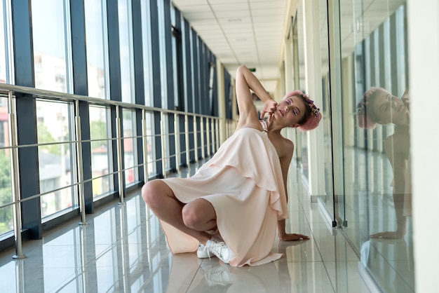 Foto a grandezza naturale di una donna romantica in posa in corridoio che indossa un abito rosa