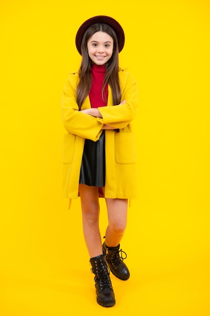 Foto a lunghezza intera di una bella bambina adolescente indossare cappotto autunnale casual isolato su sfondo giallo Ritratto di adolescente felice Ragazza sorridente