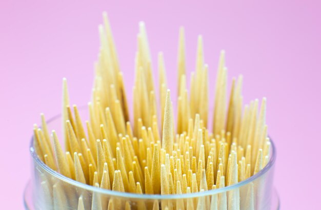 Foto a macroistruzione stuzzicadenti in legno. Primo piano, sfondo rosa.