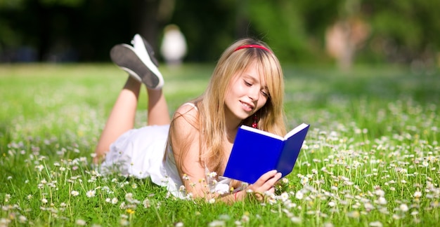 foto all'aperto di una bella ragazza adolescente con il libro