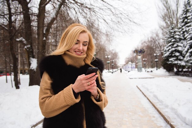 Foto alta vicina all'aperto di giovane bella ragazza sorridente felice che cammina sulla via nell'inverno