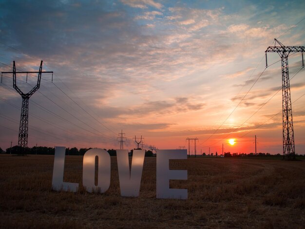 Foto amore grandi lettere di plastica su uno sfondo di cielo e tramonto