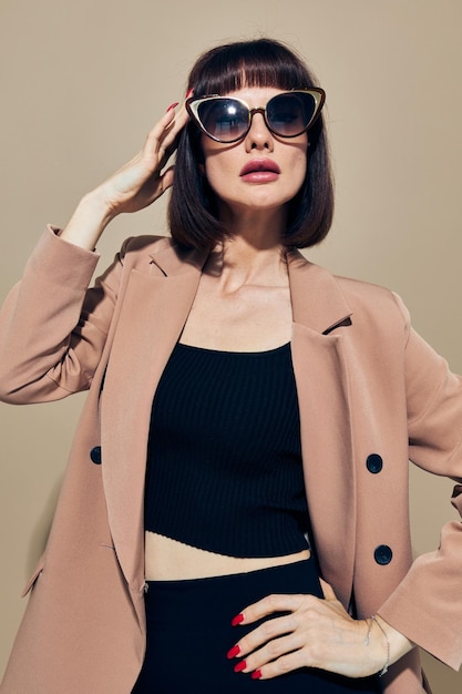 Foto bella donna in occhiali da sole vestito dai capelli corti che gesturing con le mani sfondo isolato