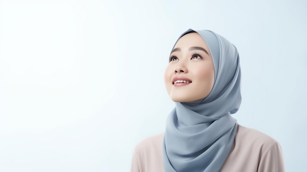 Foto bella donna musulmana asiatica in maglione blu e hijab che pensa un'idea