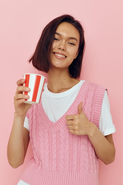 Foto bella ragazza con un bicchiere in mano estate stile maglietta rosa isolato sfondo