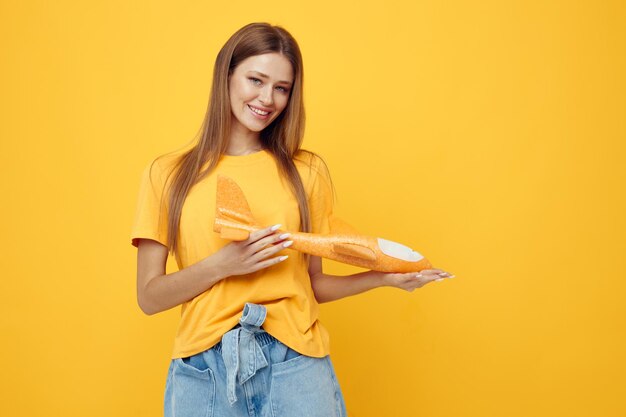 Foto bella ragazza in posa di aeroplano giallo nelle mani di divertente sfondo giallo