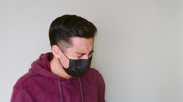 Foto concettuale dell'uomo in quarantena del coronavirus che guarda piangere in una maschera medica che fa una domanda