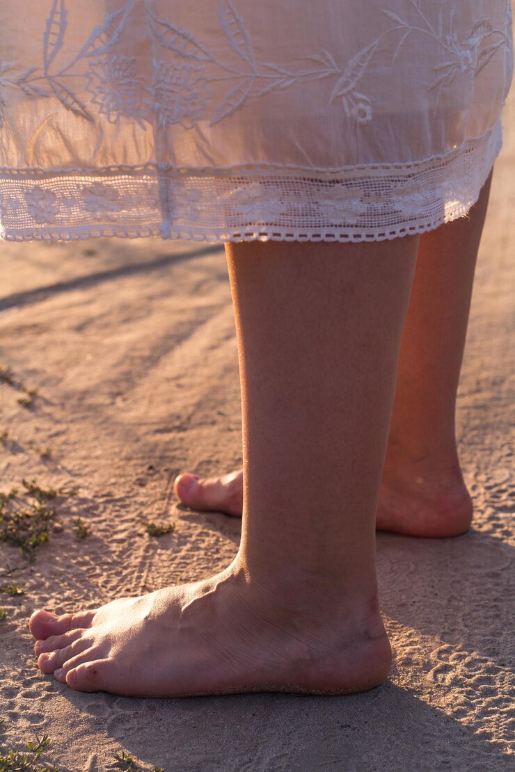 Foto foto concettuale di una donna a piedi nudi in piedi sulla sabbia