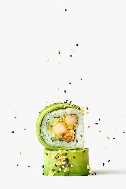 Foto creativa di involtini di sushi con avocado e gamberetti, cosparsi di semi di sesamo. Sfondo bianco, primo piano