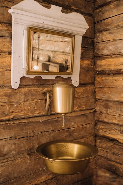 Foto d'epoca di un vecchio lavabo in metallo e specchio in una casa di legno nel villaggio