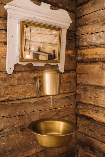 Foto d'epoca di un vecchio lavabo in metallo e specchio in una casa di legno nel villaggio