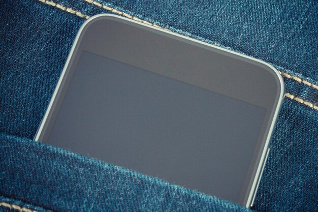 Foto d'epoca Telefono cellulare con schermo vuoto in tasca jeans smartphone