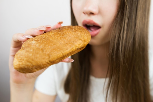 Foto da vicino di una donna che mangia un croissant