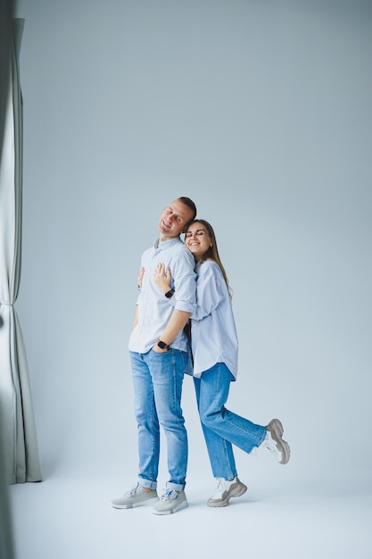 Foto del concetto di relazione di una coppia felice in camicie bianche e jeans su sfondo bianco Felice giovane coppia