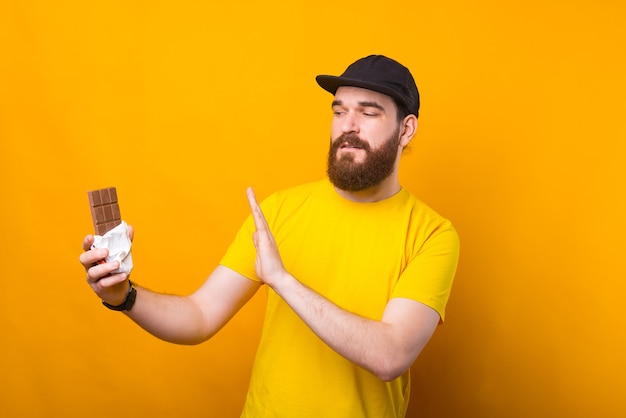 Foto del giovane con la barba che dice NO al cioccolato