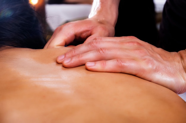 Foto del massaggio. Ragazza, massaggio, spa. Foto di una donna sottoposta a massaggio alla schiena.