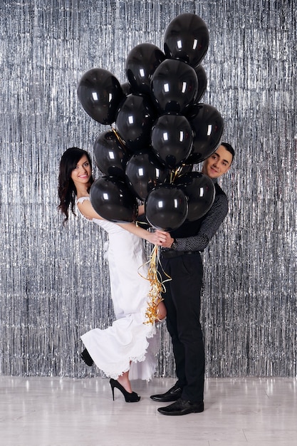 Foto del matrimonio. Coppia giovane con palline nere su sfondo scintillante